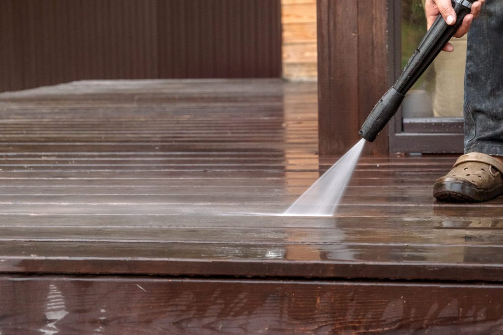 man cleaning a wooden deck